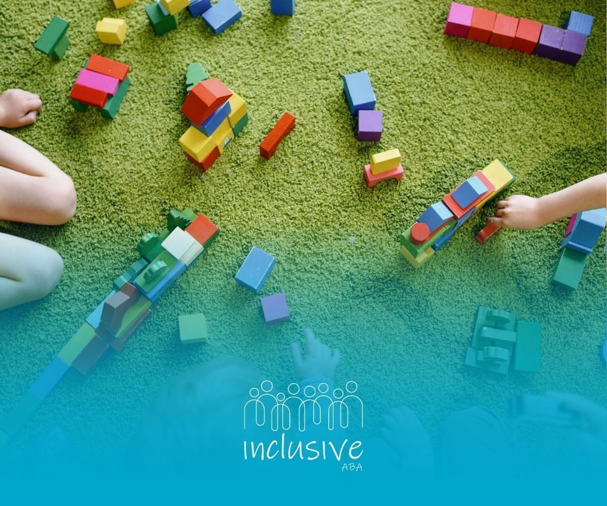 Autistic children building with colorful blocks on a green carpet during ABA therapy session in NE.