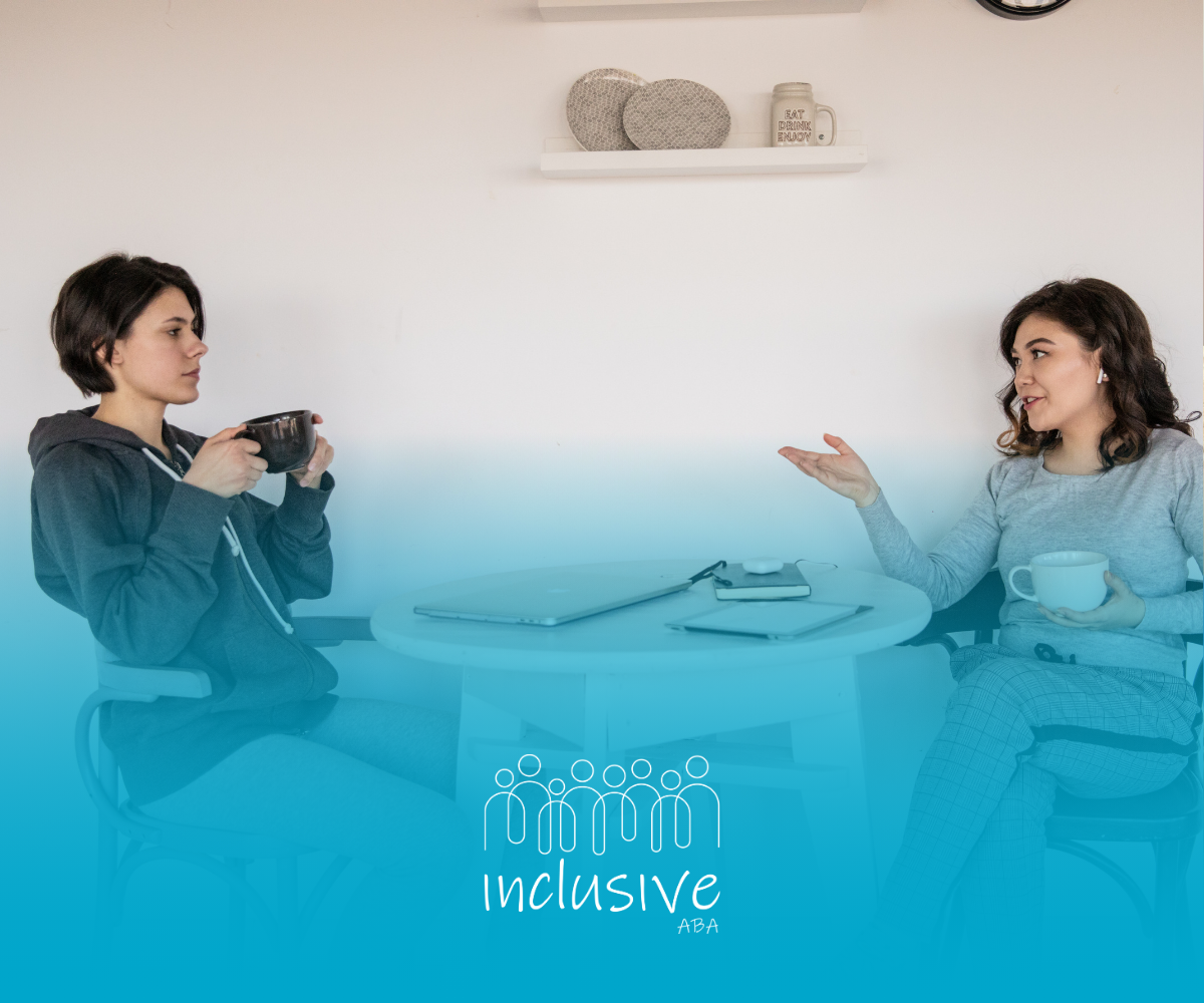 Two women are sitting at a table talking to each other.