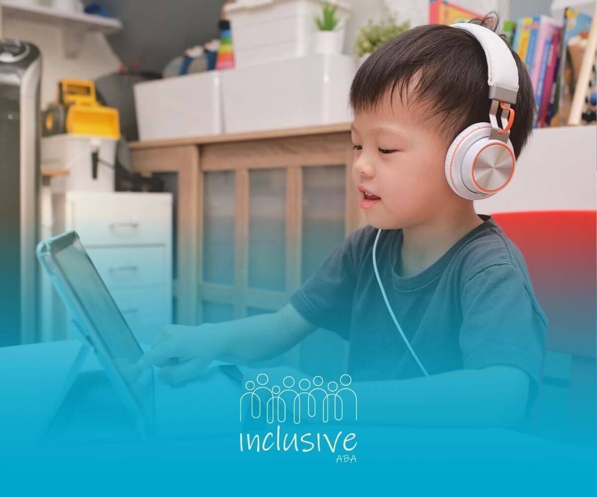 A young boy wearing headphones is using a tablet computer after in-home ABA therapy.