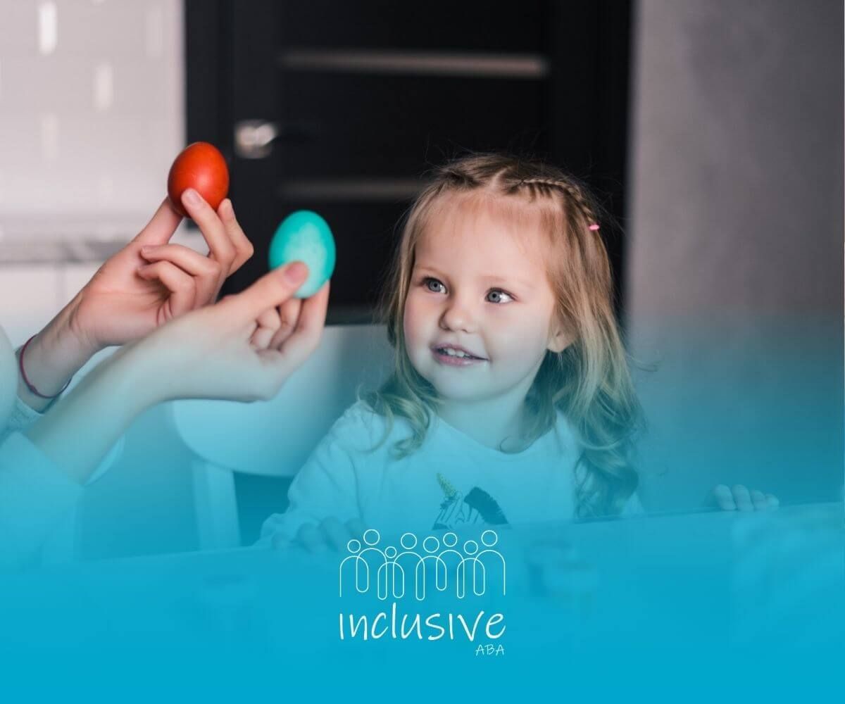 A little girl is sitting at a table with an ABA therapist holding an easter egg in ABA therapy.