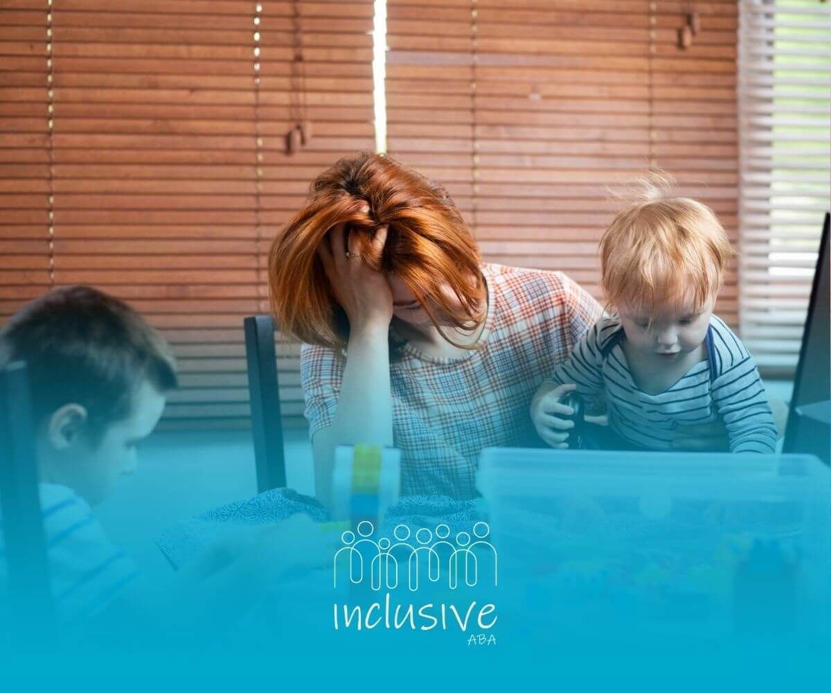 A struggling is sitting at a table with two autistic children playing with lego blocks.