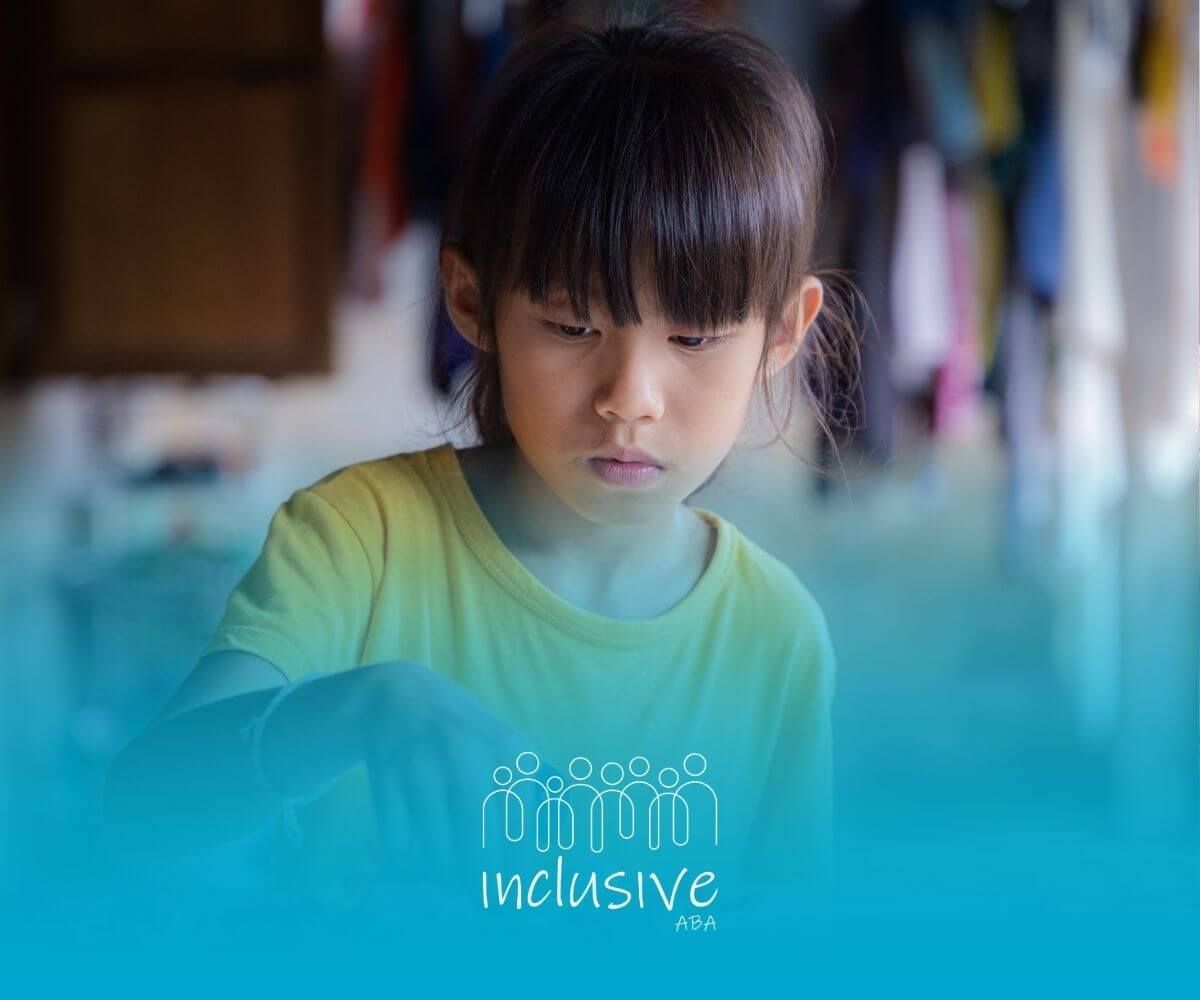 A child with nonverbal autism is sitting at a table playing with toys.