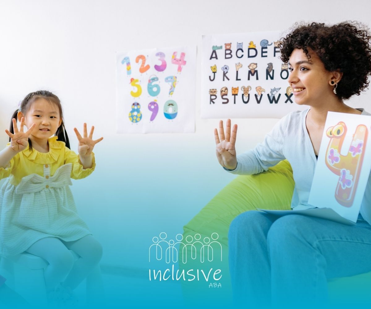 Teacher and child using sign language beside colorful alphabet and number charts in a classroom setting