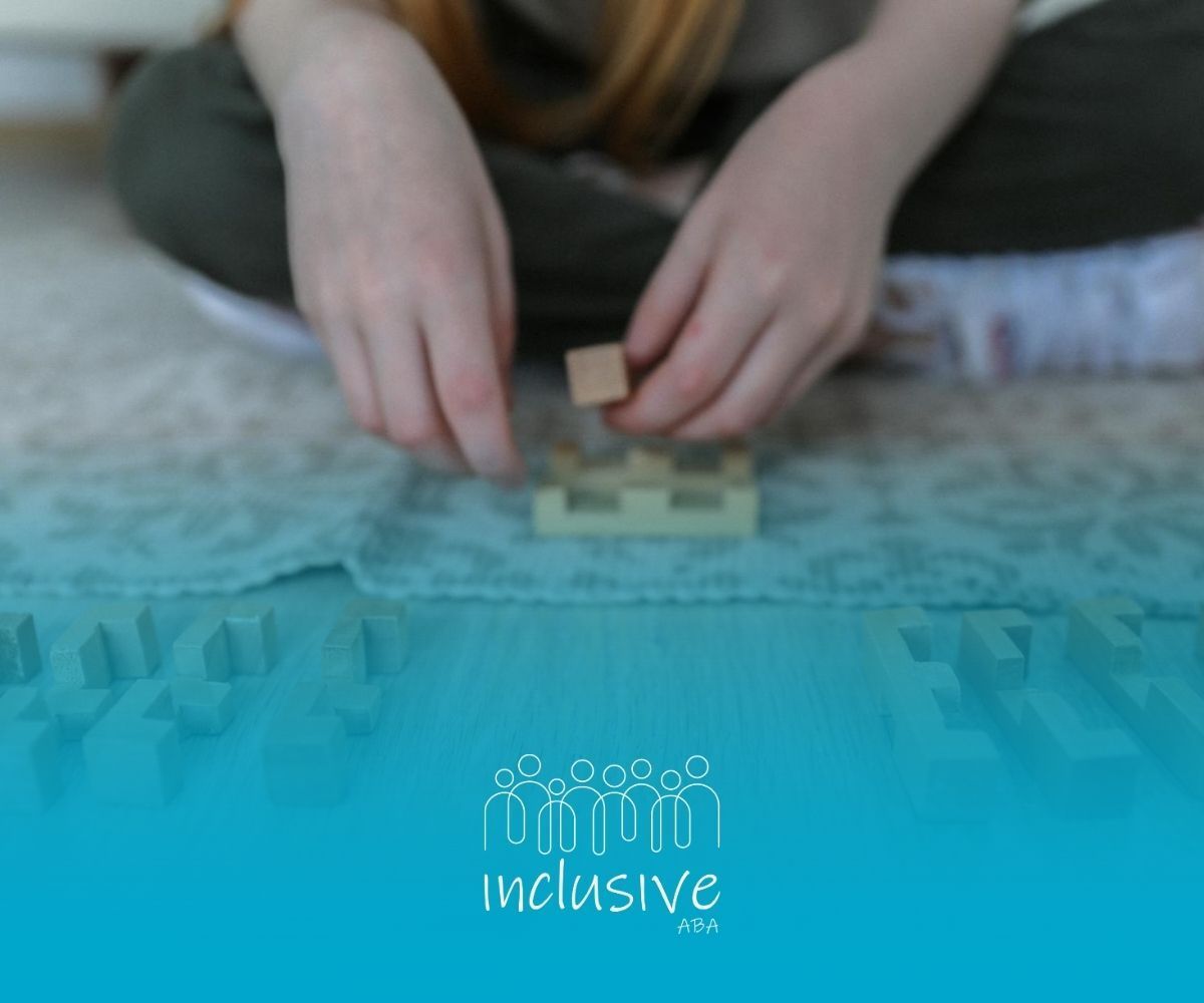 An autistic child playing with wooden building blocks on the floor during ABA therapy session in CO.