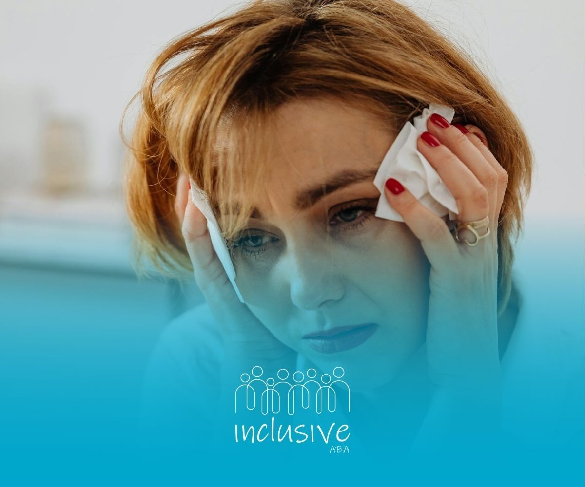 Autistic woman looking distressed while holding tissues to her temples after formal diagnosis in NV.