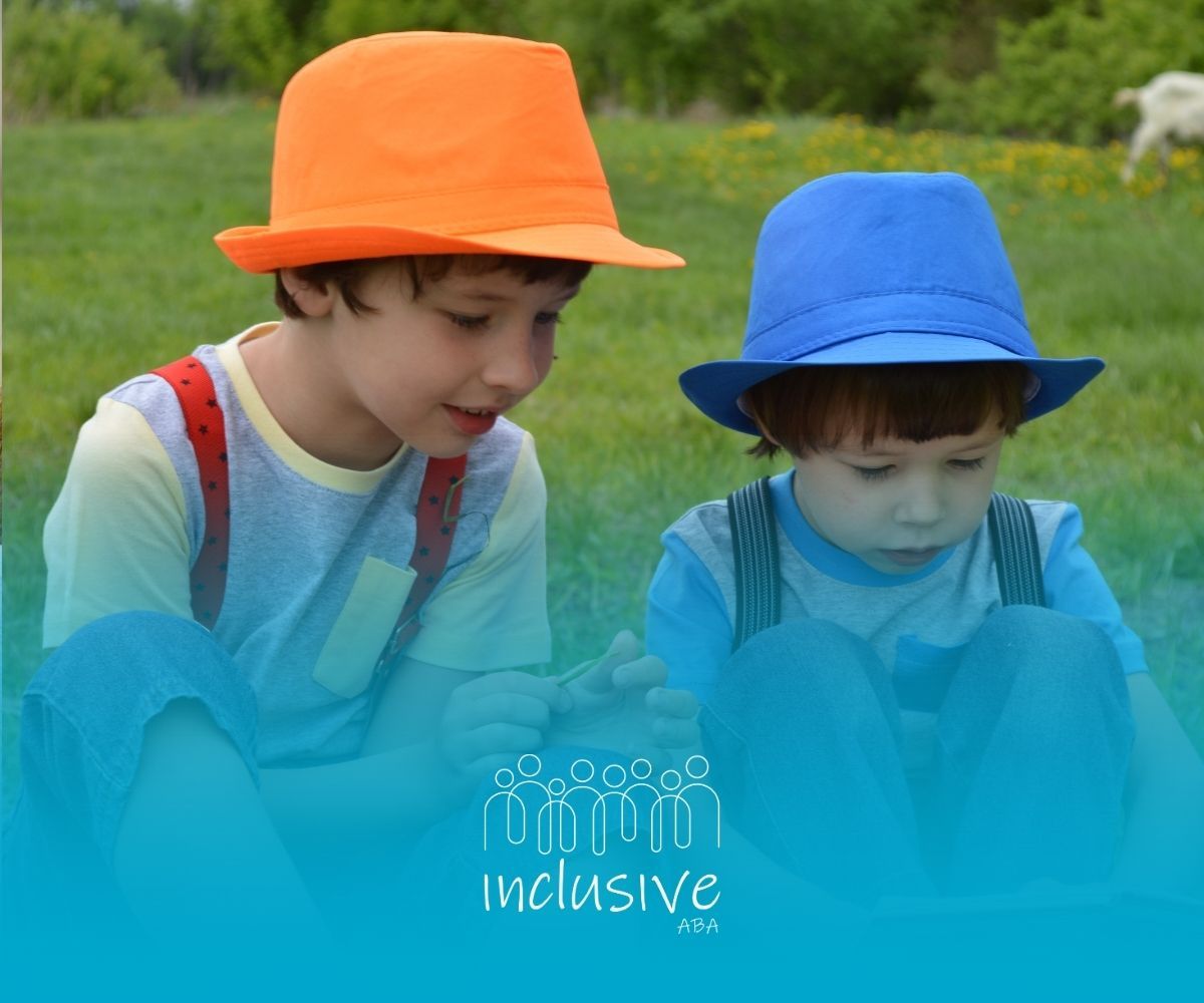 Two children in orange and blue hats looking down in a grassy field with a blue overlay and logo.