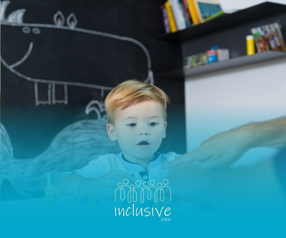 A child sits at a table playing with small colorful figurines while an adult reaches toward them.