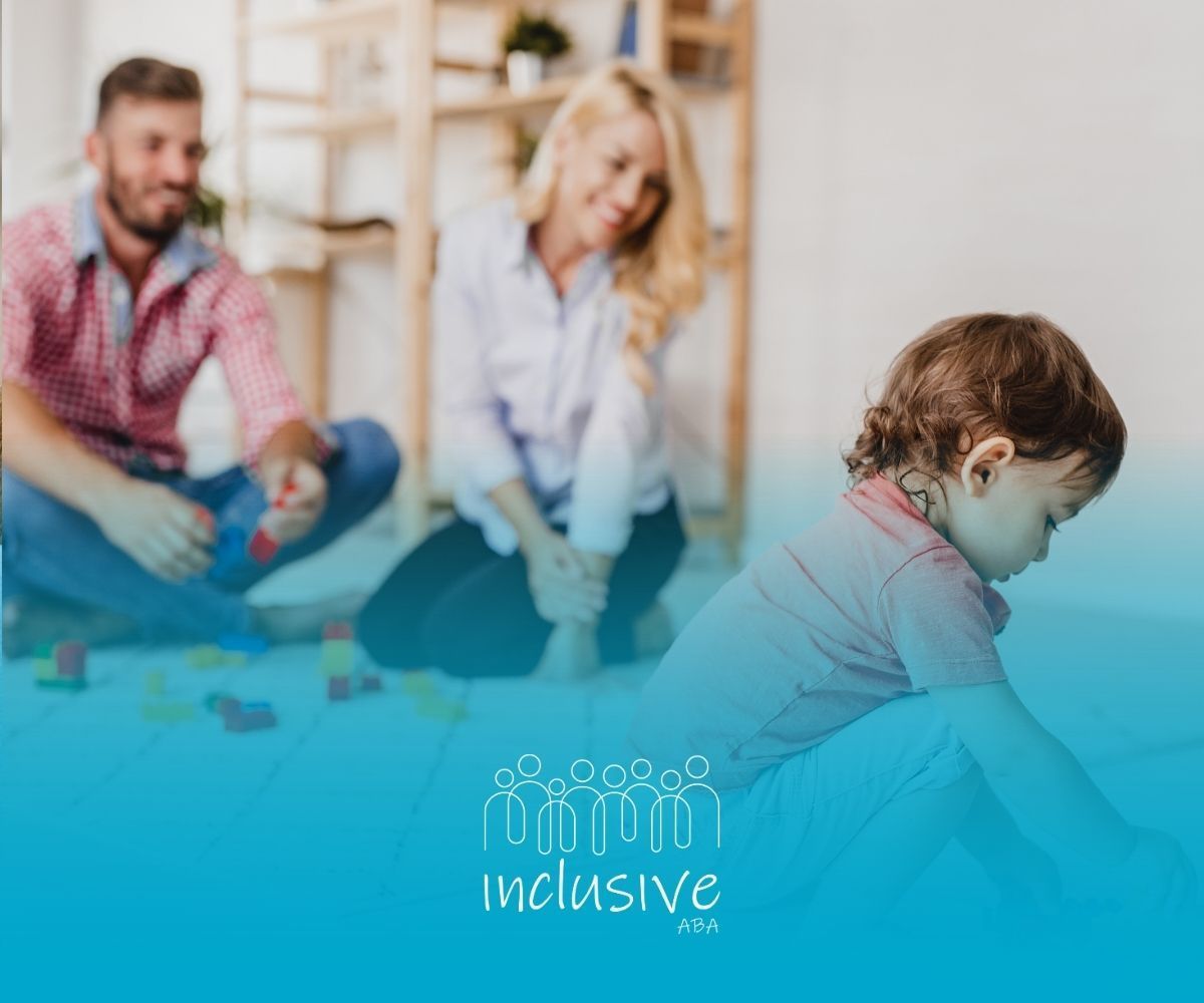 A child plays in the foreground with parents watching in the background, overlaid with the Inclusive logo.