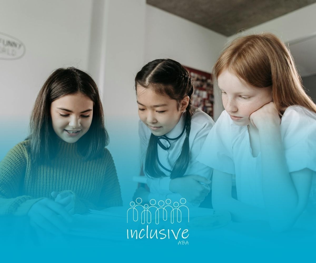 Three autistic girls studying together and sharing notes in class during school-based ABA therapy.