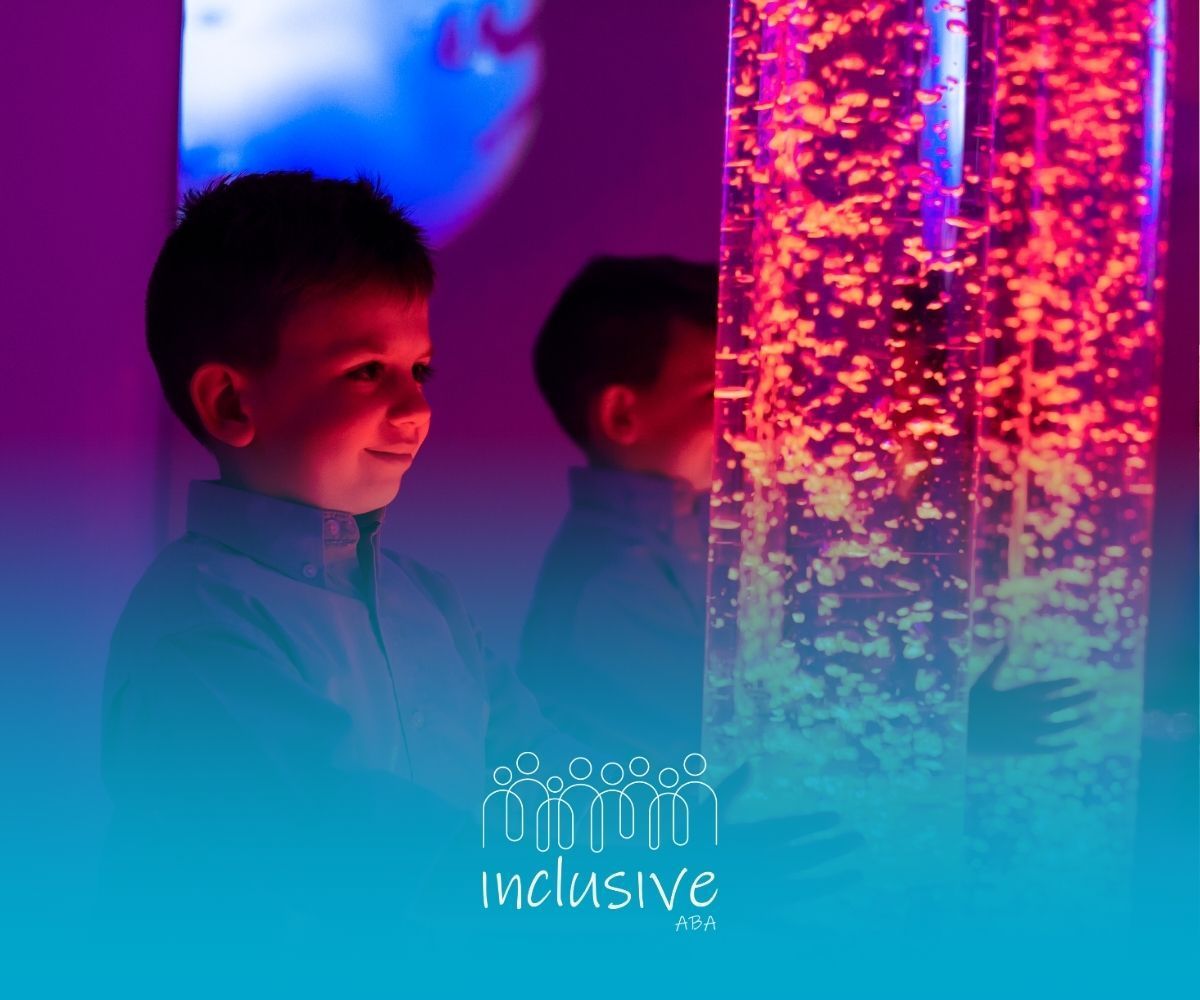Two young boys are playing with bubble tubes in a sensory room.
