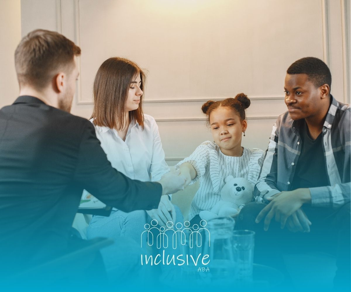 A family is sitting on a couch talking to a man.