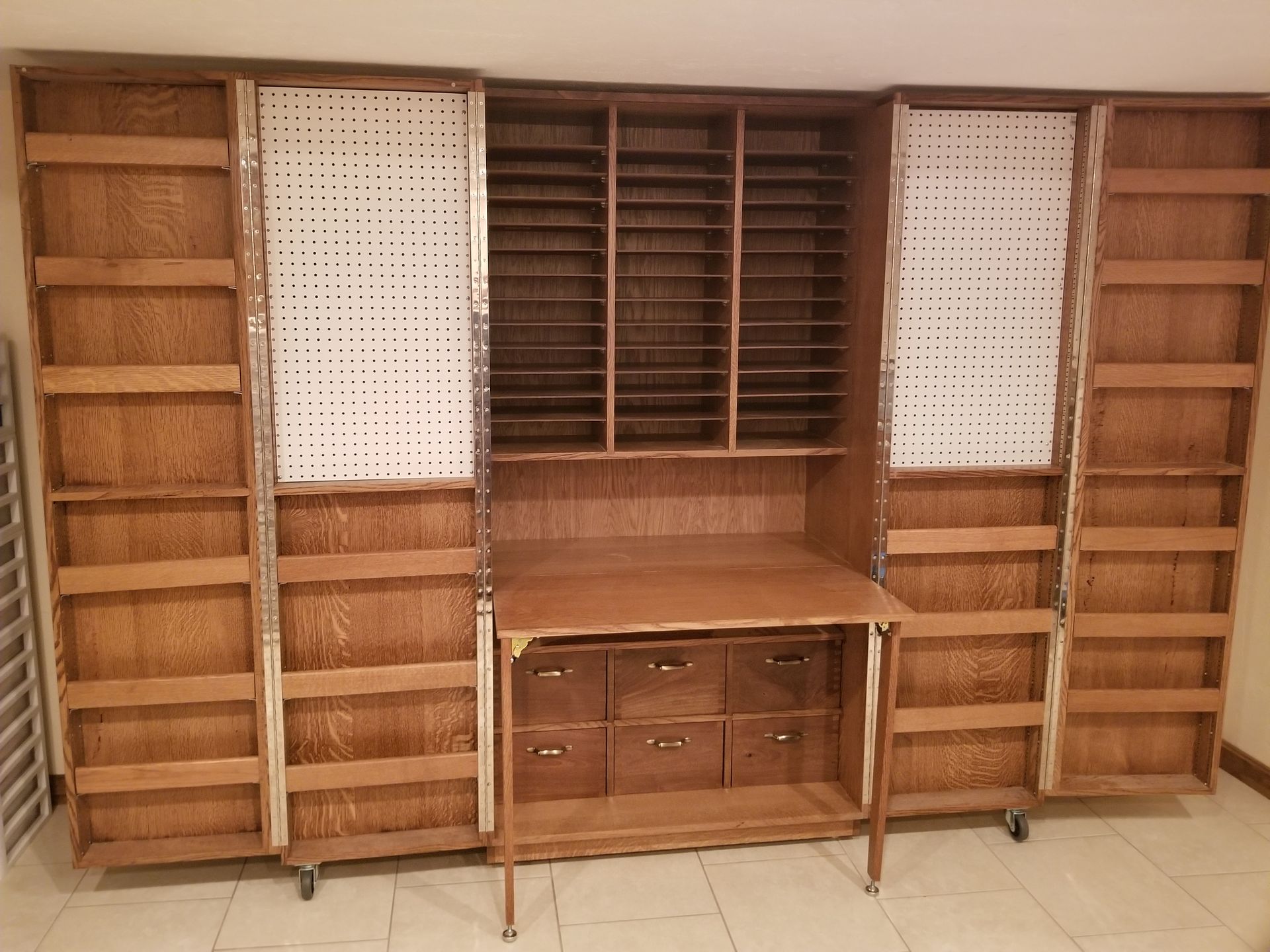 A large wooden cabinet with lots of shelves and drawers
