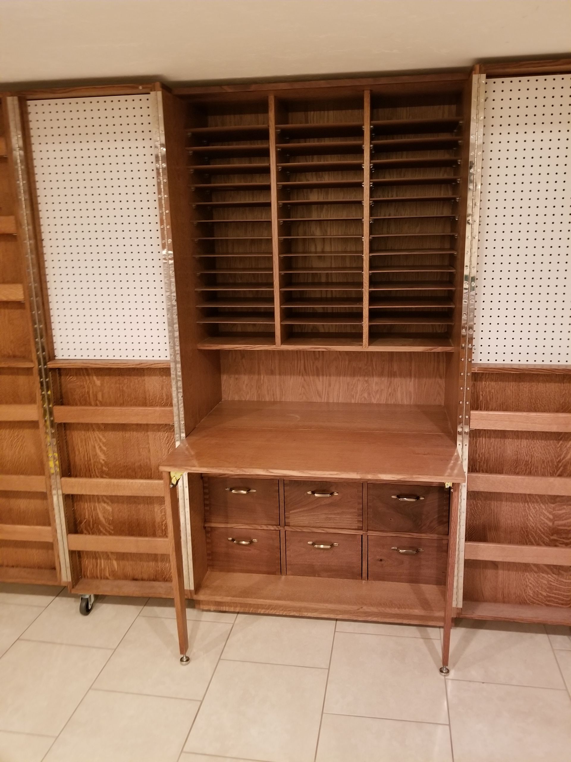 A large wooden cabinet with lots of shelves and drawers