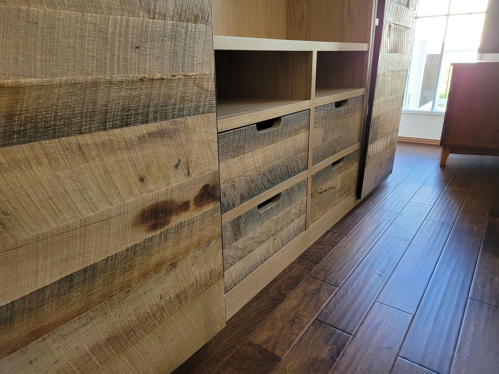 A wooden cabinet with drawers and shelves in a living room.