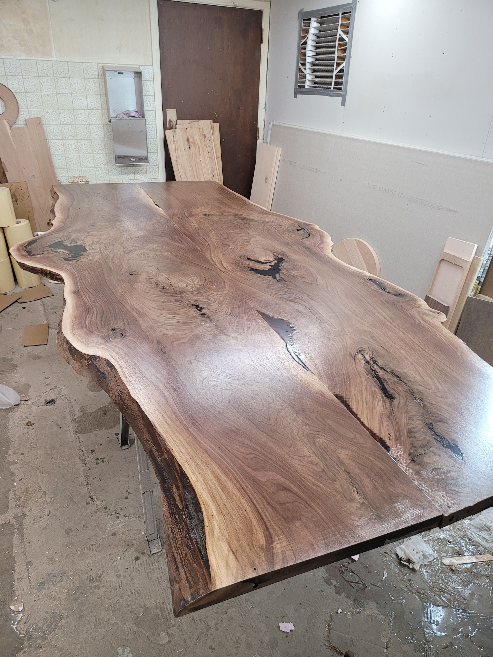 A large wooden table is sitting on the floor in a room.
