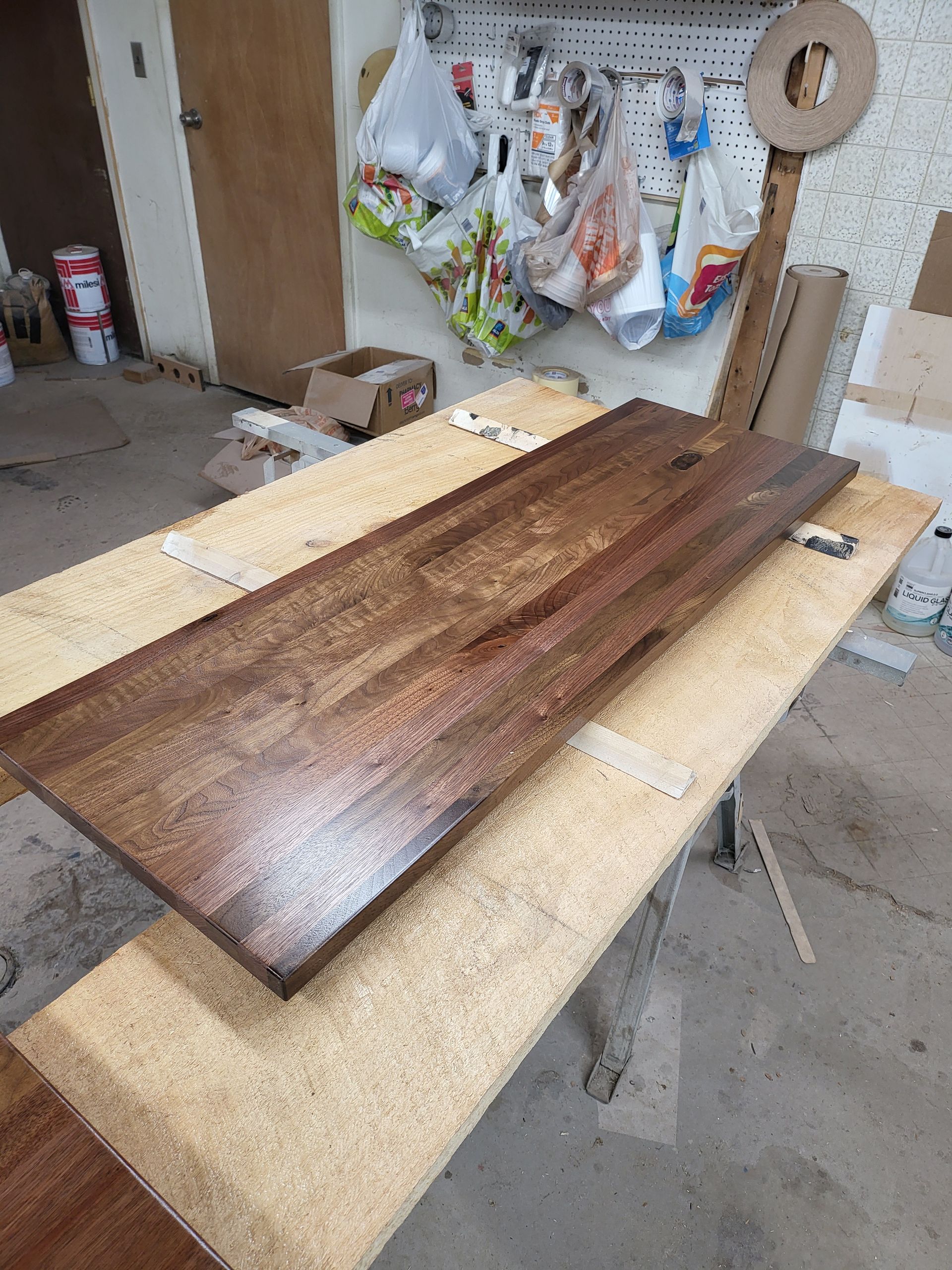 A long piece of wood is sitting on top of a wooden table.