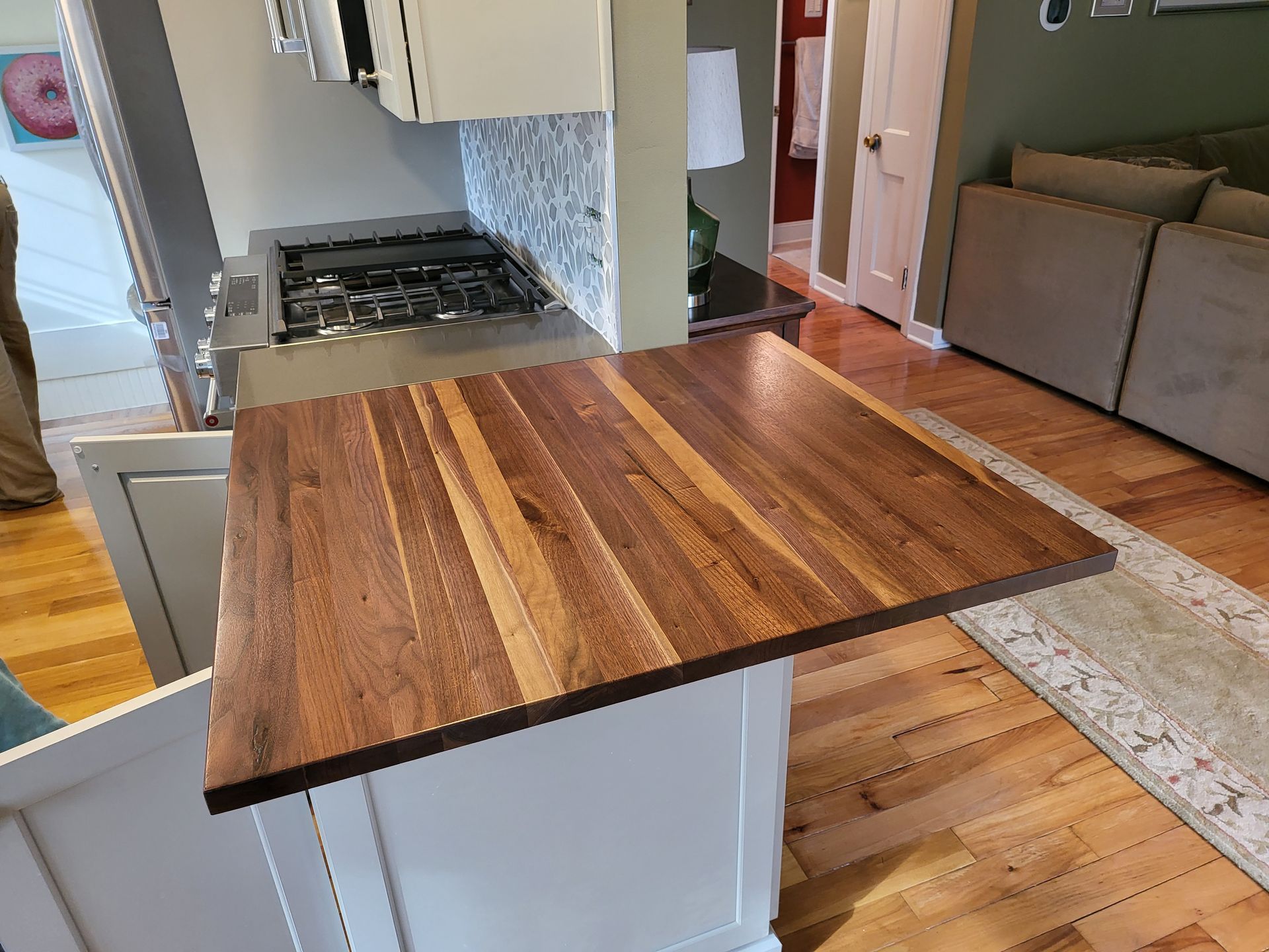 A kitchen with a wooden counter top and a stove top oven.