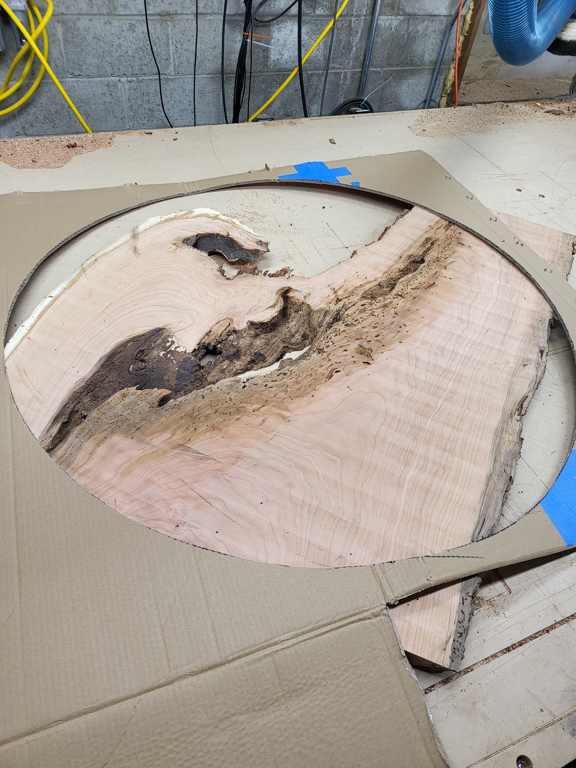 A piece of wood is sitting on top of a cardboard box.