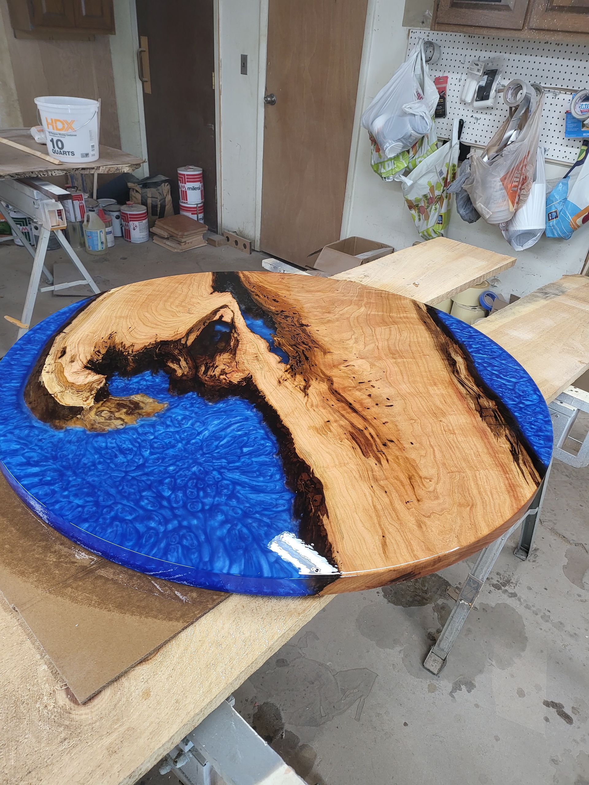 A wooden table with a blue resin coating is sitting on top of a wooden table.