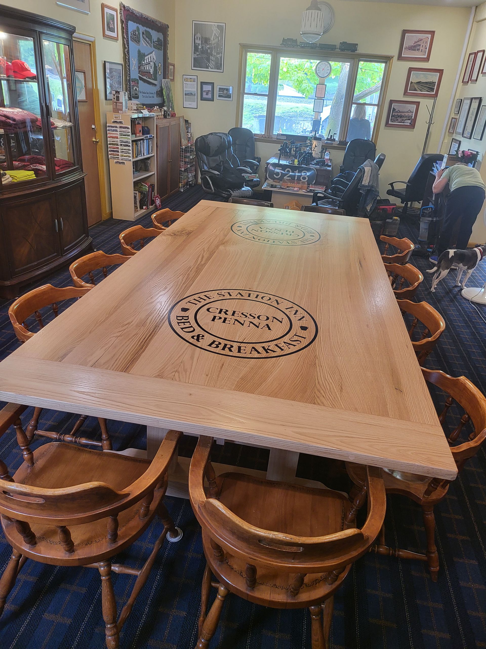 A large wooden table is sitting in a room with chairs.