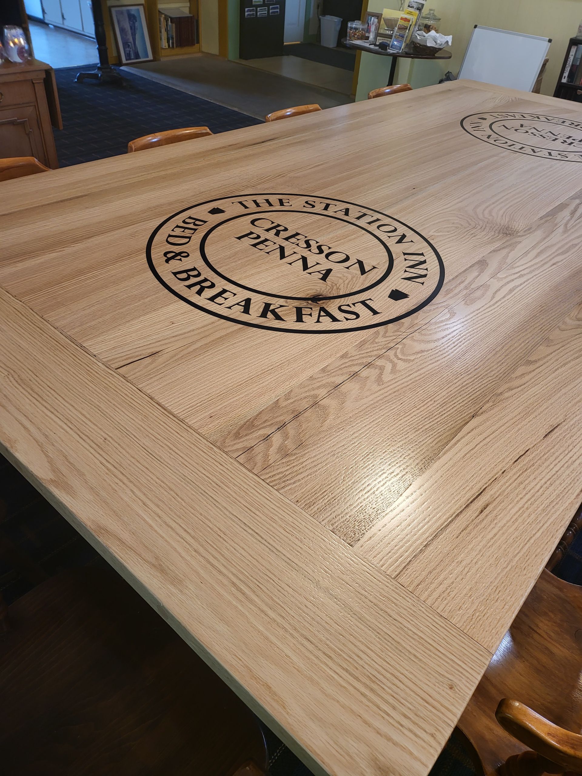 A wooden table with a logo on it in a room.