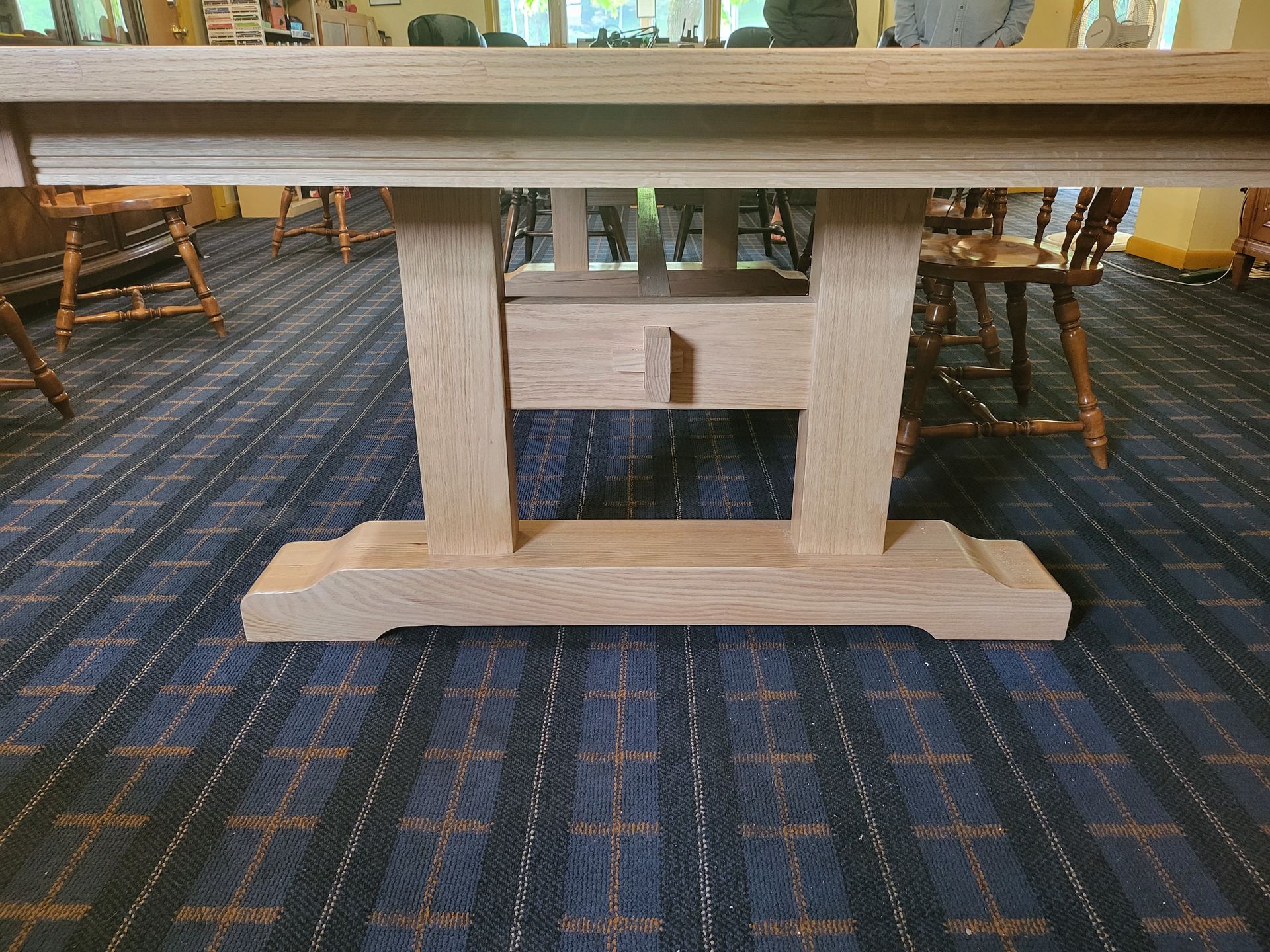 A wooden table is sitting on a blue carpet in a room.