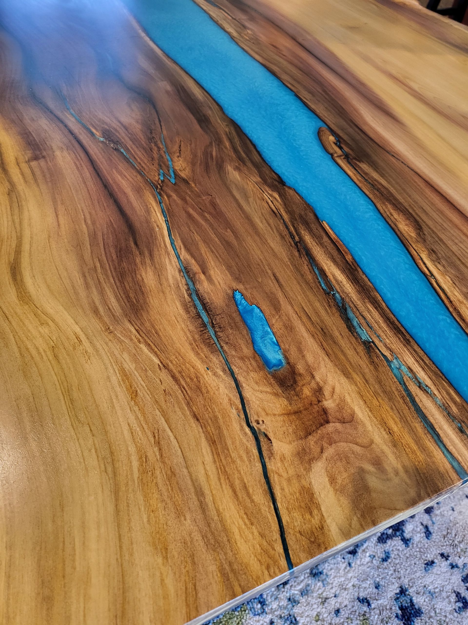 A wooden table with a blue river in the middle of it.