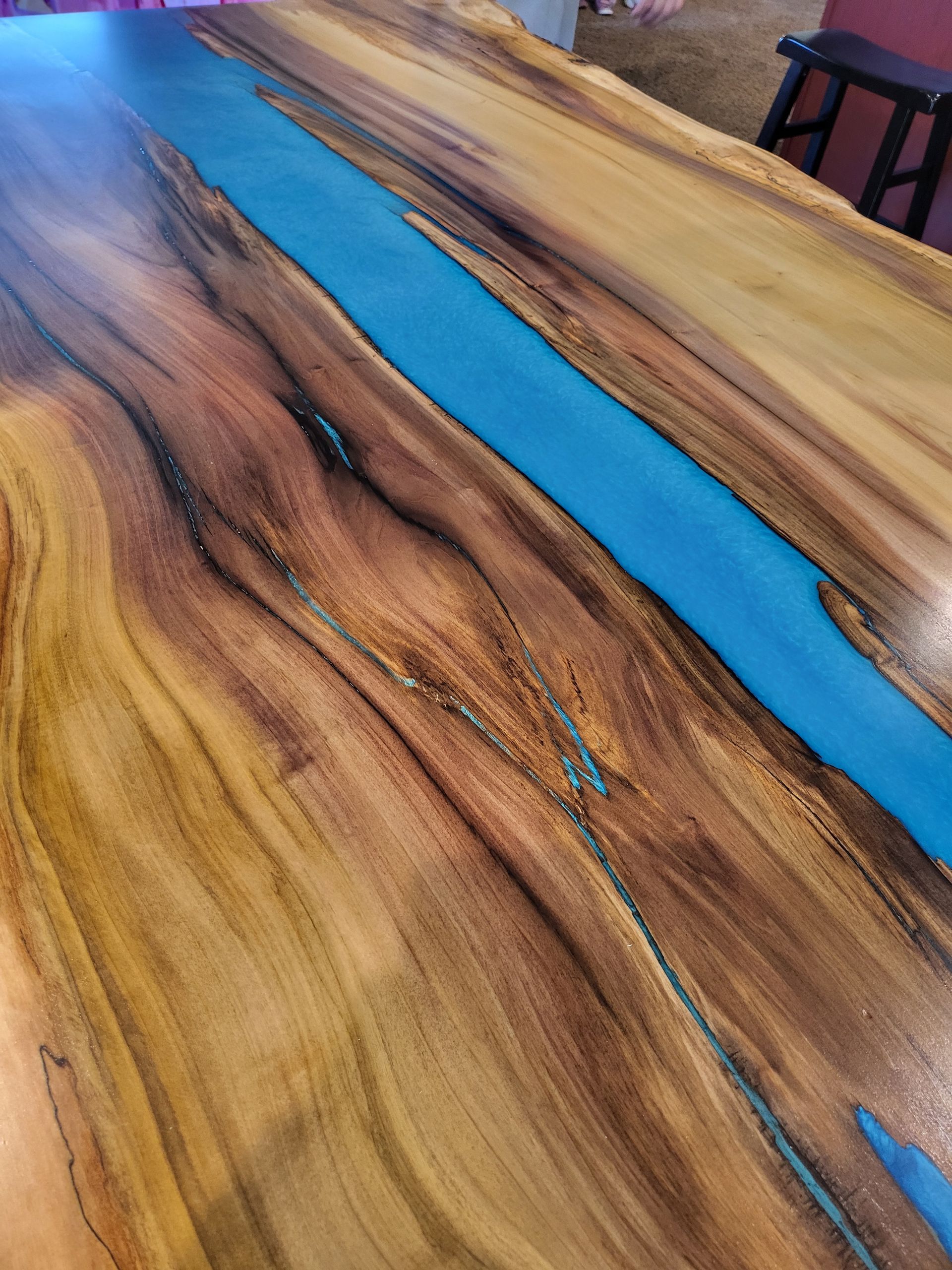 A wooden table with a blue river running through it.