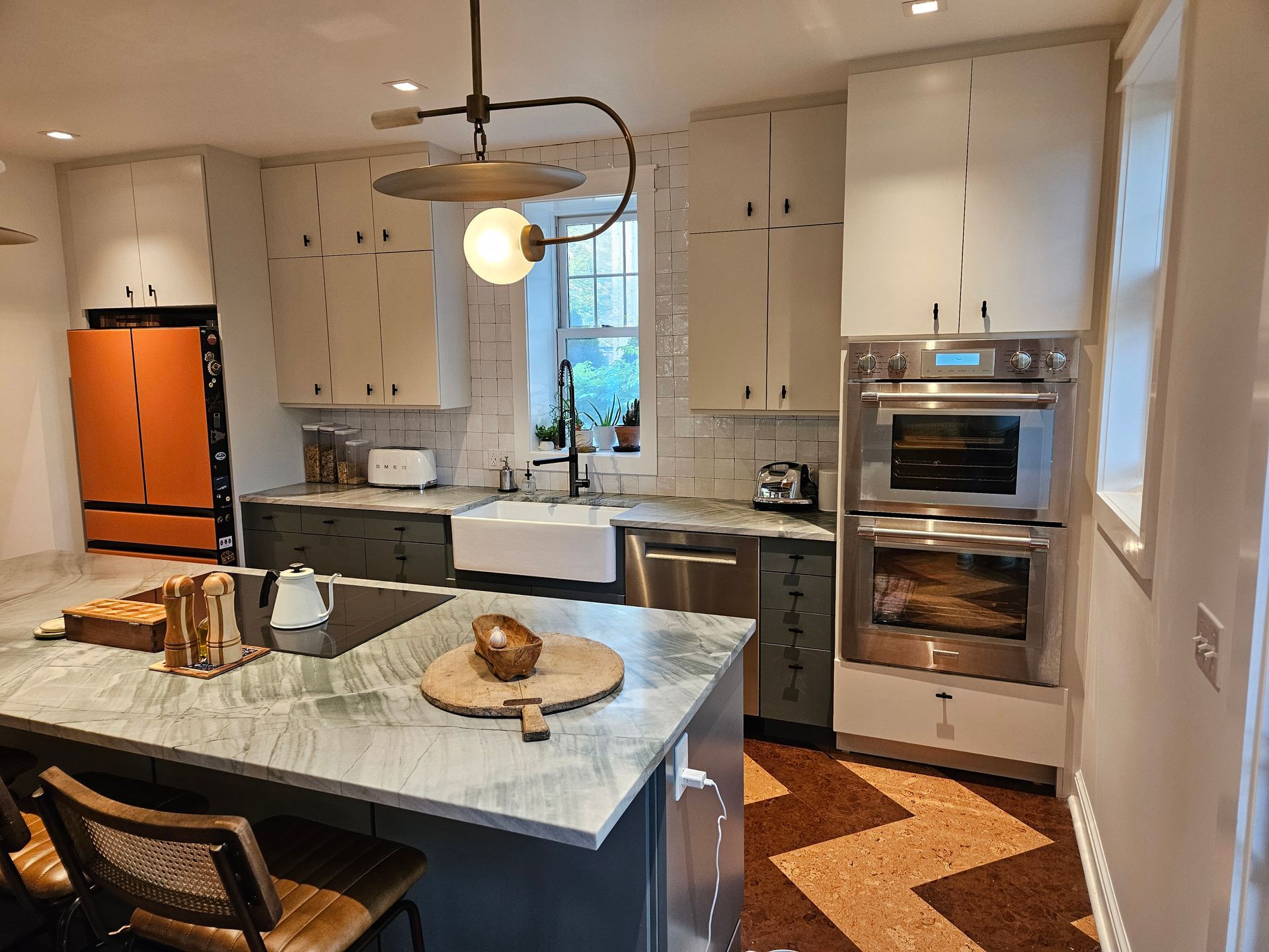 A kitchen with stainless steel appliances and a large island in the middle.