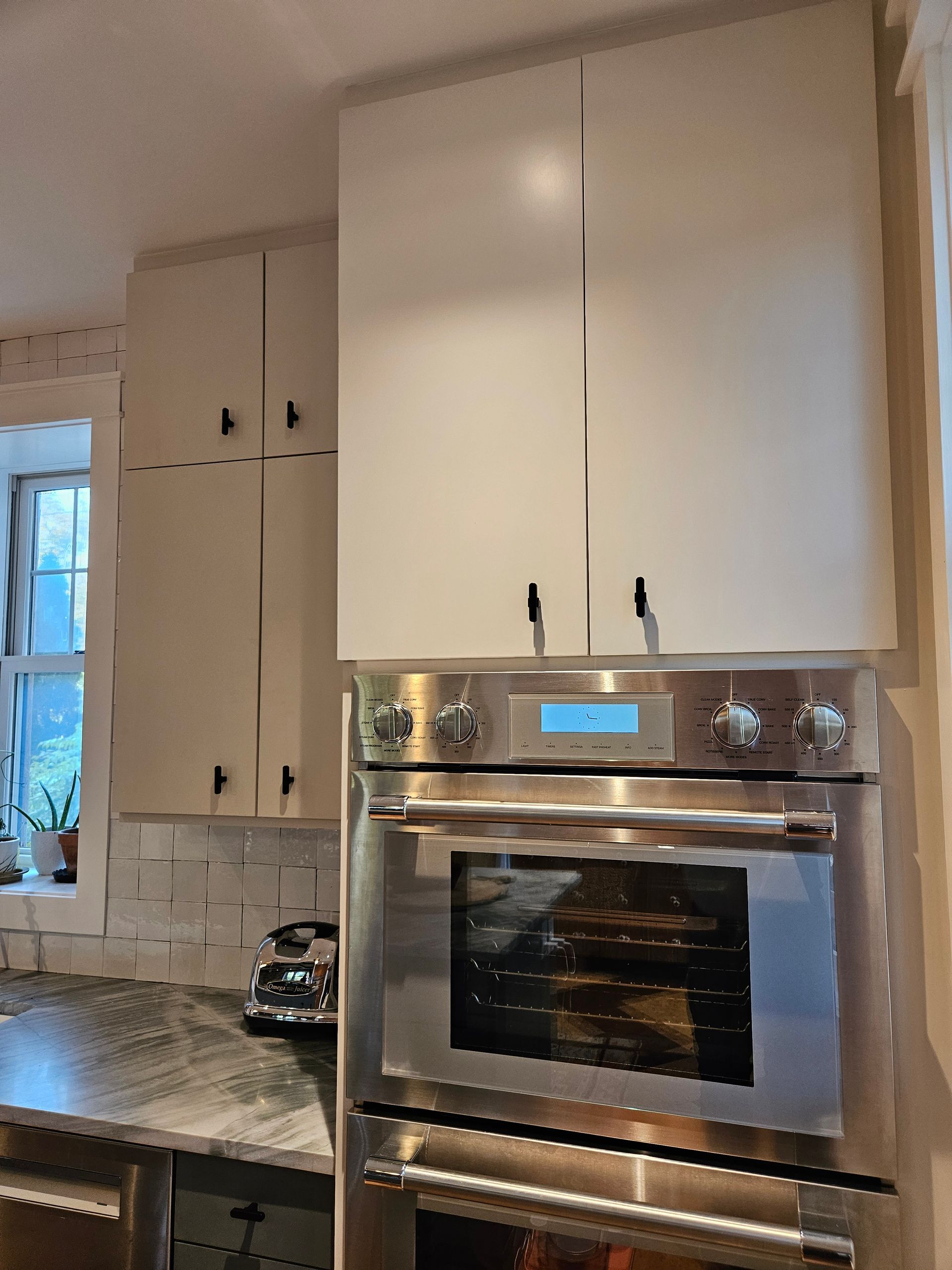A kitchen with stainless steel appliances and white cabinets