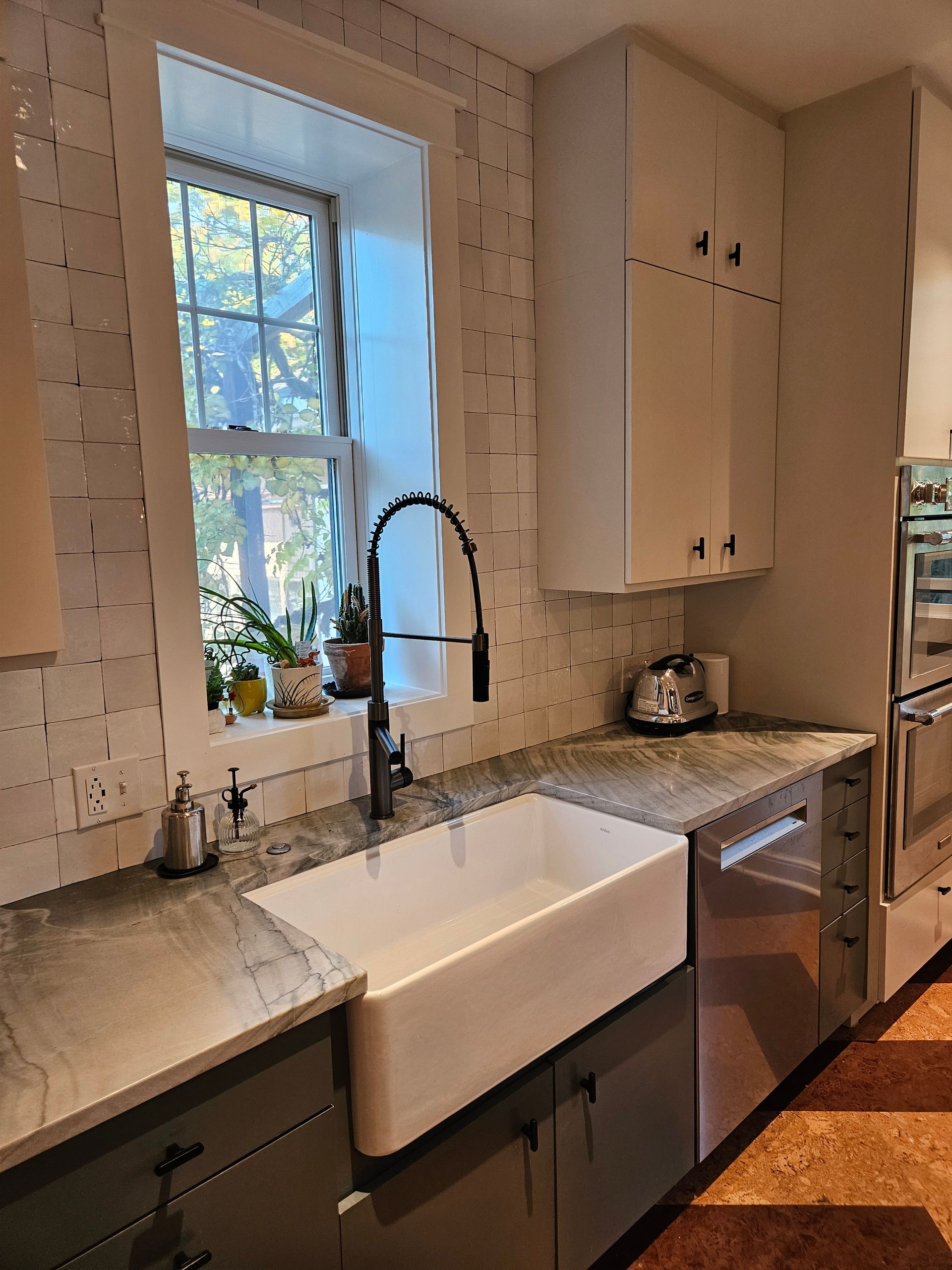 A kitchen with a white sink and a window