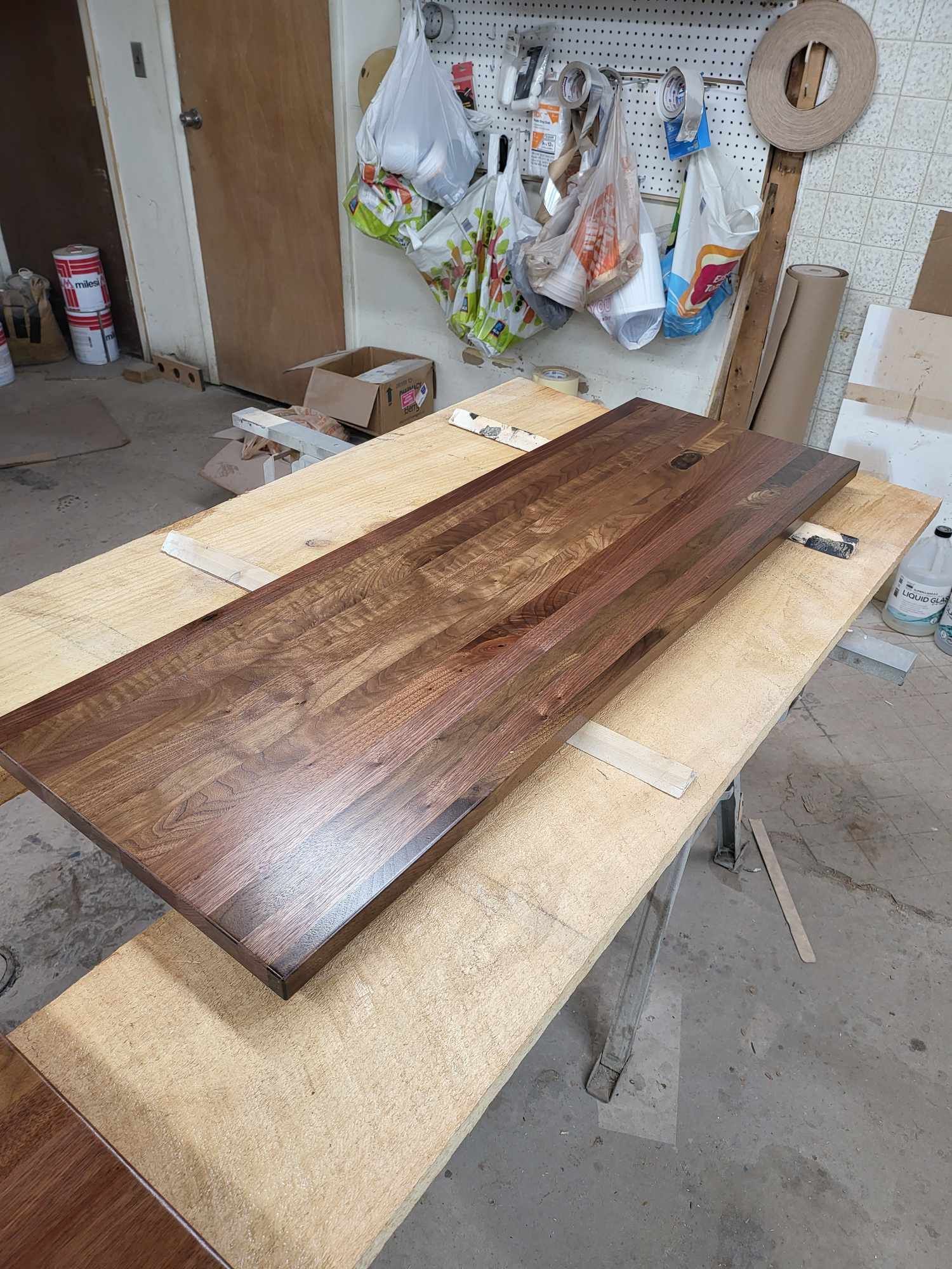 A long piece of wood is sitting on top of a wooden table.