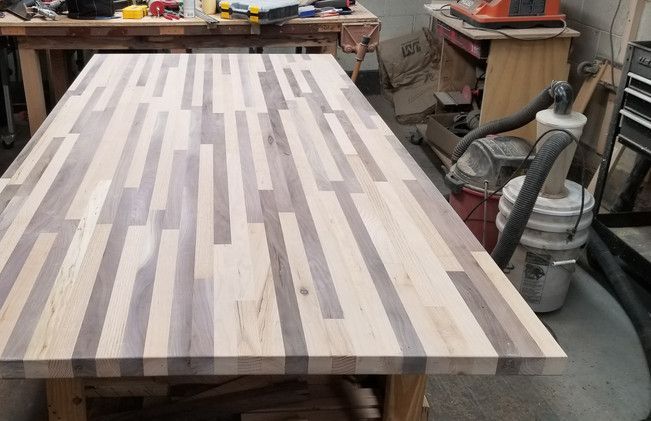 A wooden table with a vacuum cleaner in the background