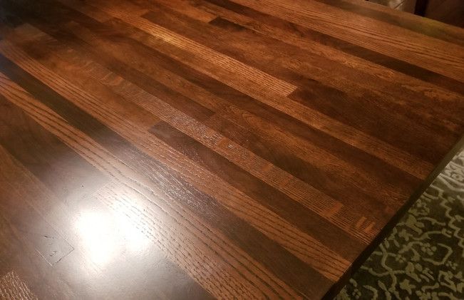 A close up of a wooden table top on a rug.