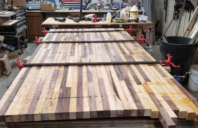 A wooden table is being glued together in a workshop.