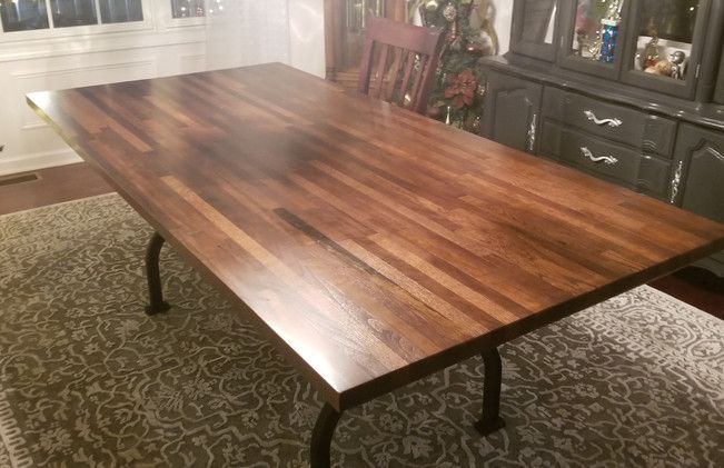 A wooden table is sitting on top of a rug in a dining room.