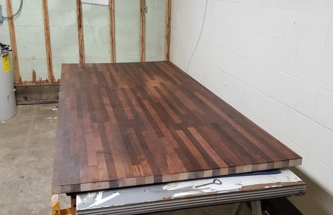 A large piece of wood is sitting on top of a metal table.