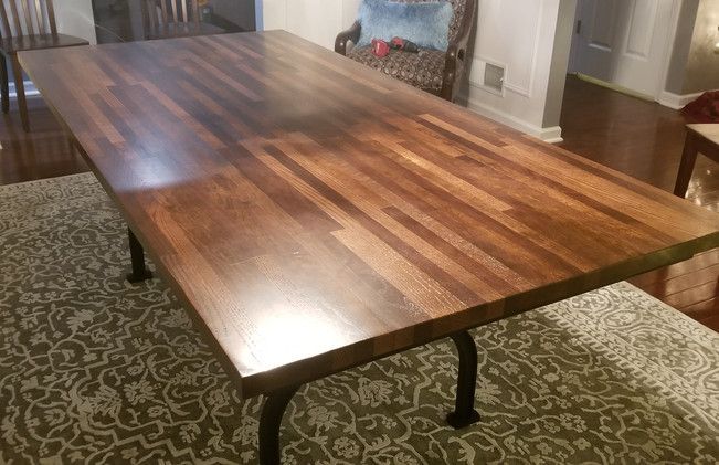 A long wooden table is sitting on a rug in a living room.