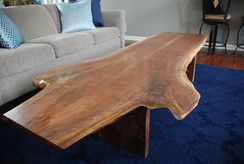 A wooden coffee table is sitting in a living room next to a couch.