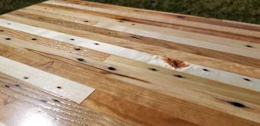 A wooden table is sitting on top of a lush green field.