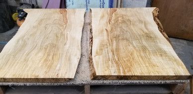 Two pieces of wood are sitting on top of a wooden pallet.