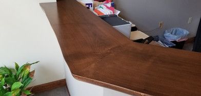 A wooden counter in a room with a plant and a printer.