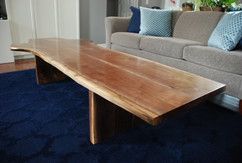 A wooden coffee table is sitting in a living room next to a couch.