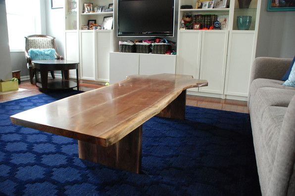 A living room with a large wooden coffee table and a couch.