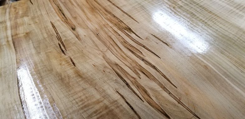 A close up of a wooden table with a shiny finish.