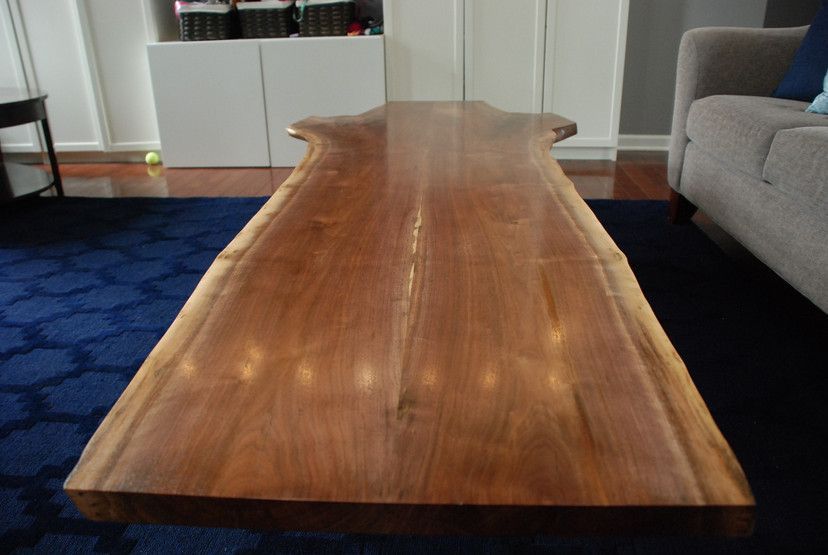A long wooden table in a living room next to a couch