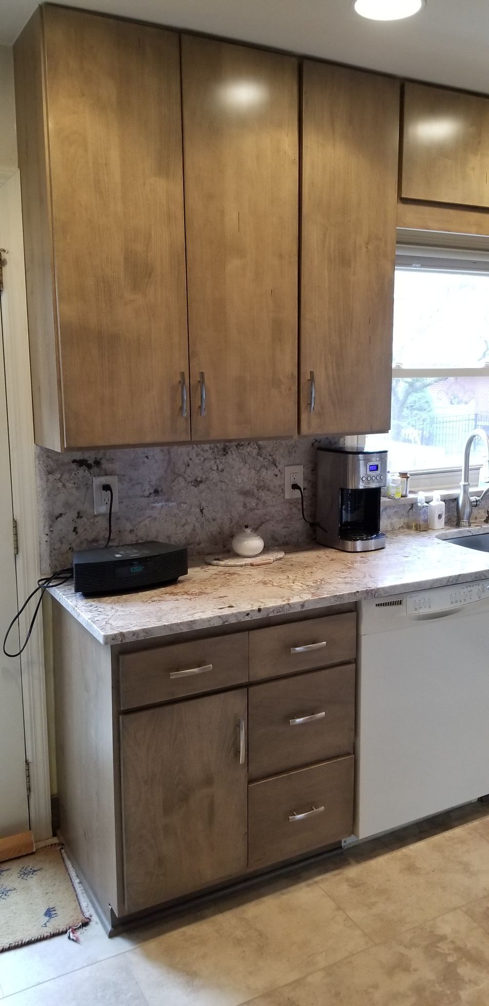 A kitchen with wooden cabinets and a white dishwasher.