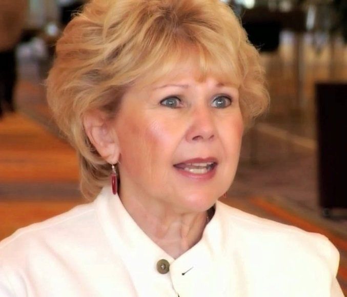 Um close de uma mulher vestindo uma jaqueta branca e brincos