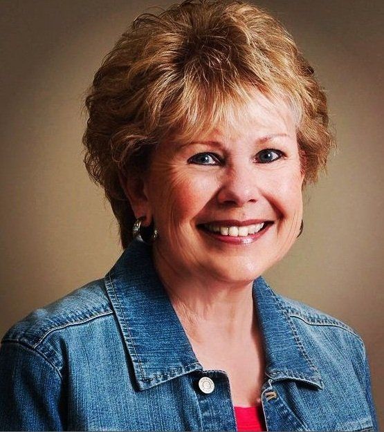 Uma mulher vestindo uma jaqueta jeans está sorrindo para a câmera