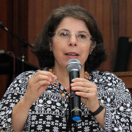 Uma mulher de óculos está segurando um microfone